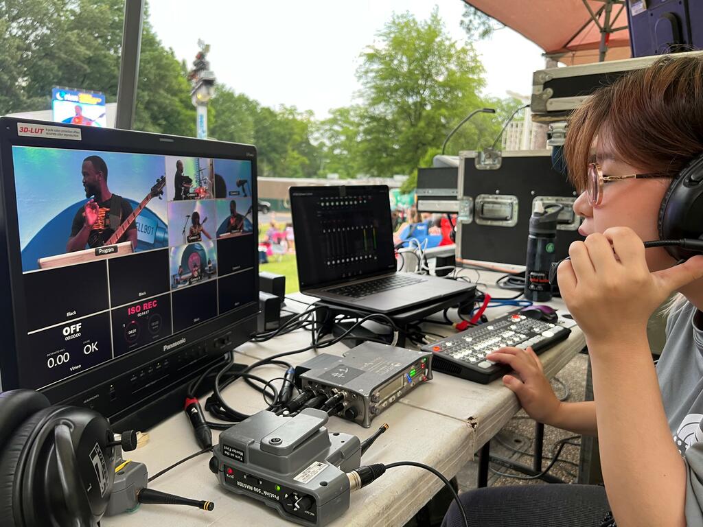 a young Mongolian woman works a sound board at an outdoor concert