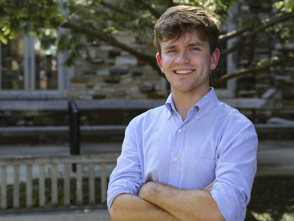 a young man smiles at the camera