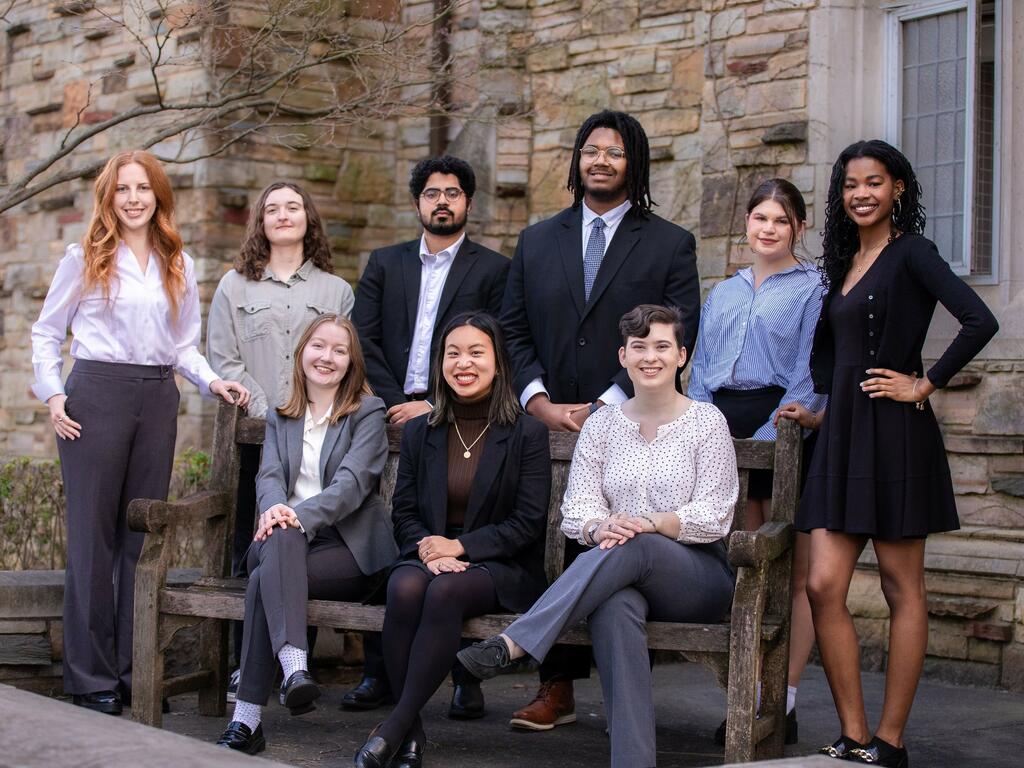 group image of Rhodes College students standing and sitting outside a campus building