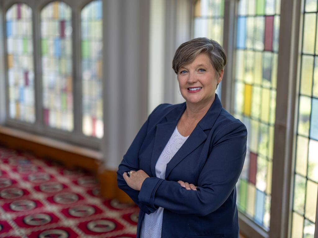 image of Carole Blankenship standing in front of a stained glass window