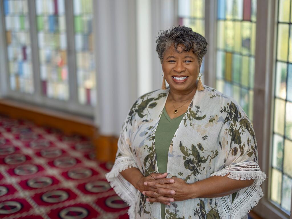 image of Darlene Brooks standing in front a stained glass window