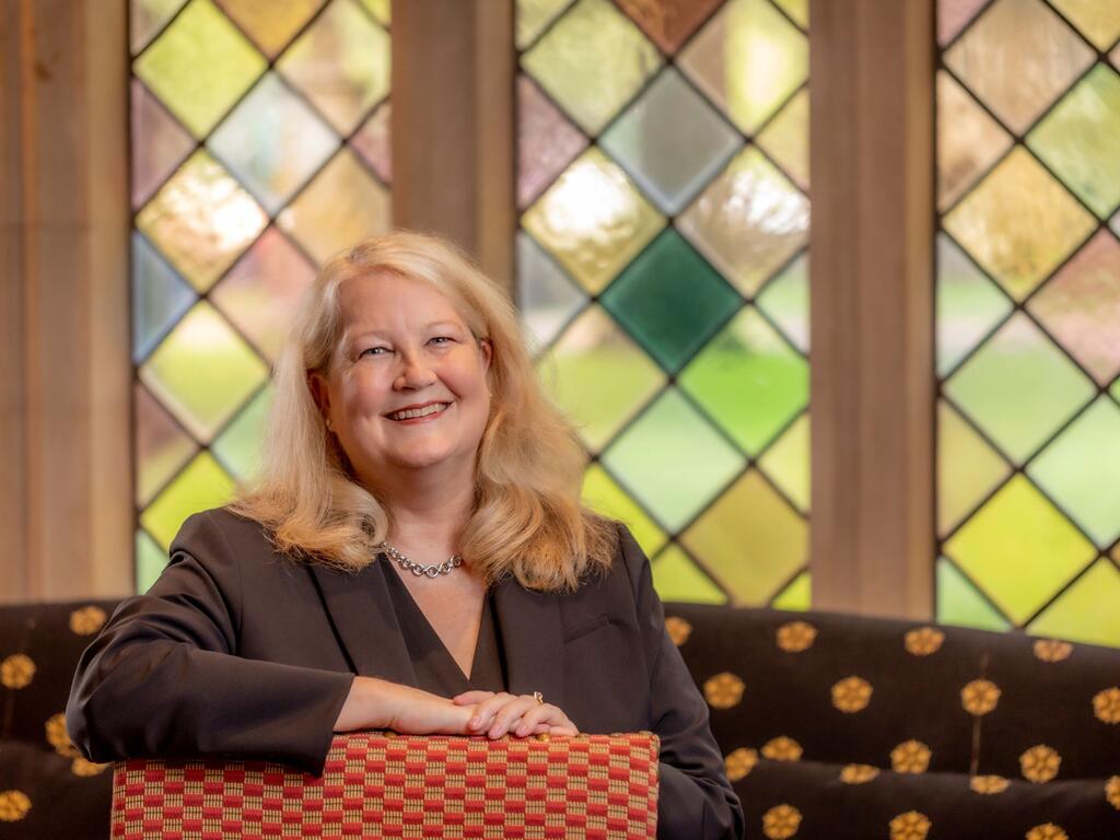 image of Jennifer Collins sitting in front of a stained glass window