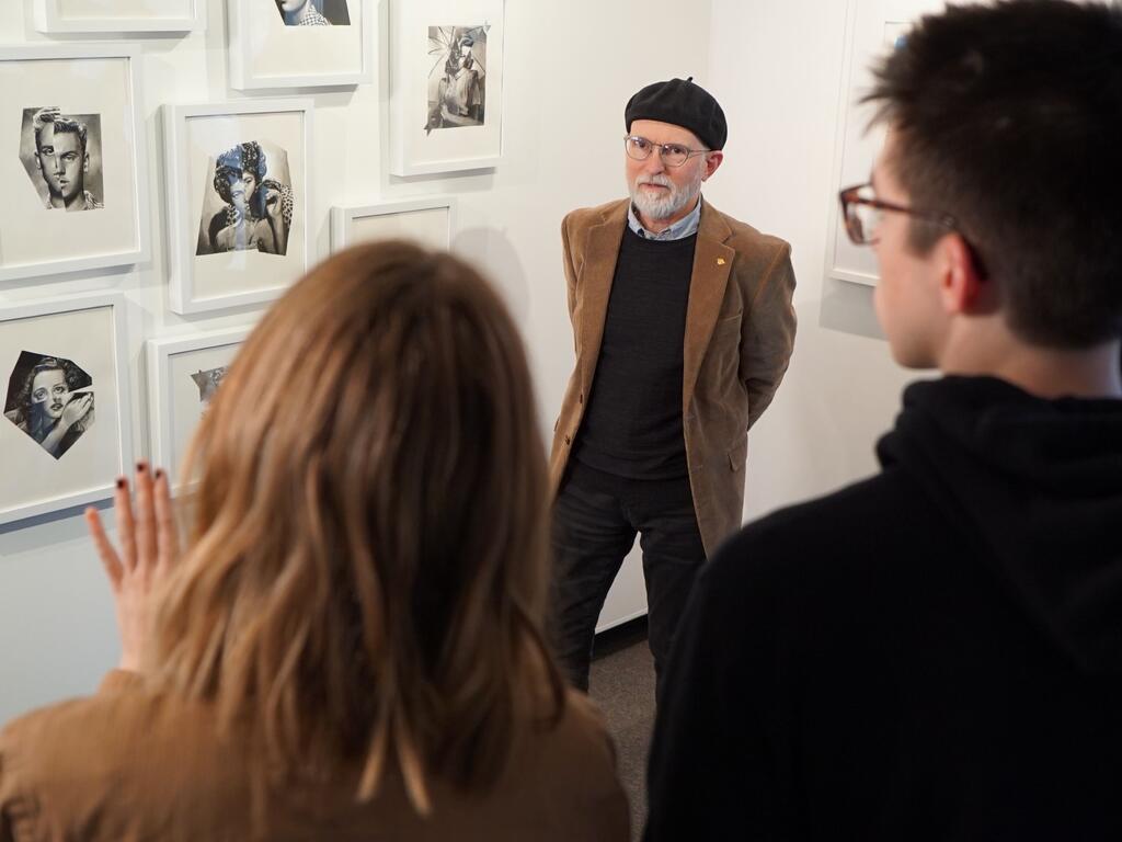 image of Prof. McCarthy with students in front of an art wall