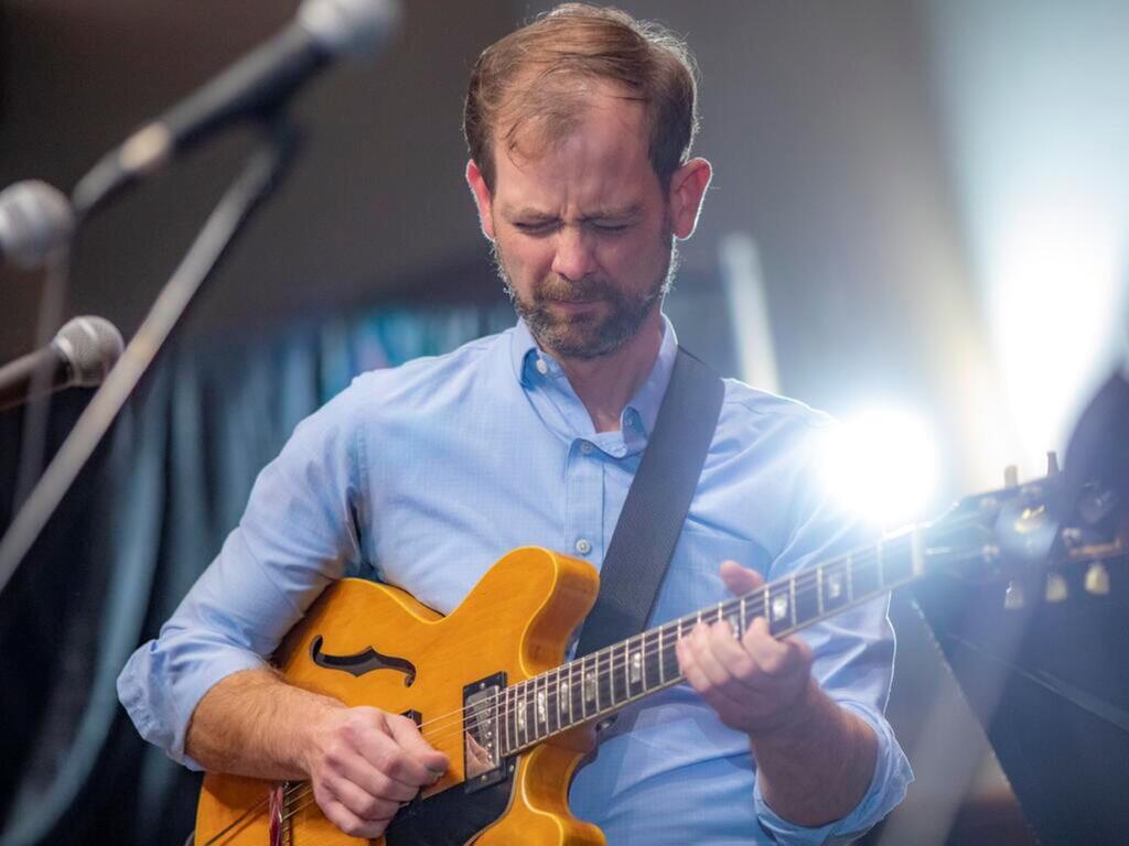 image of John Bass playing the guitar