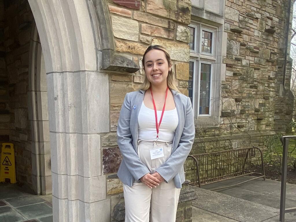 image of Dania Verbena standing outside of a campus building