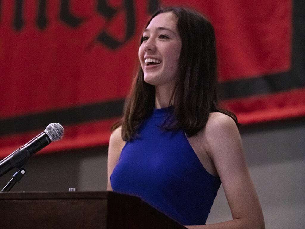 a young woman speaks at a podium