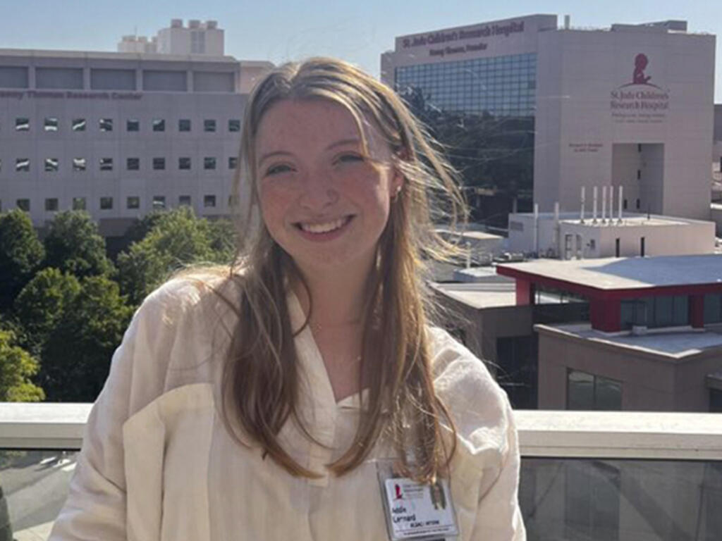 a young woman poses in front of St. Jude Children's Research Hospital