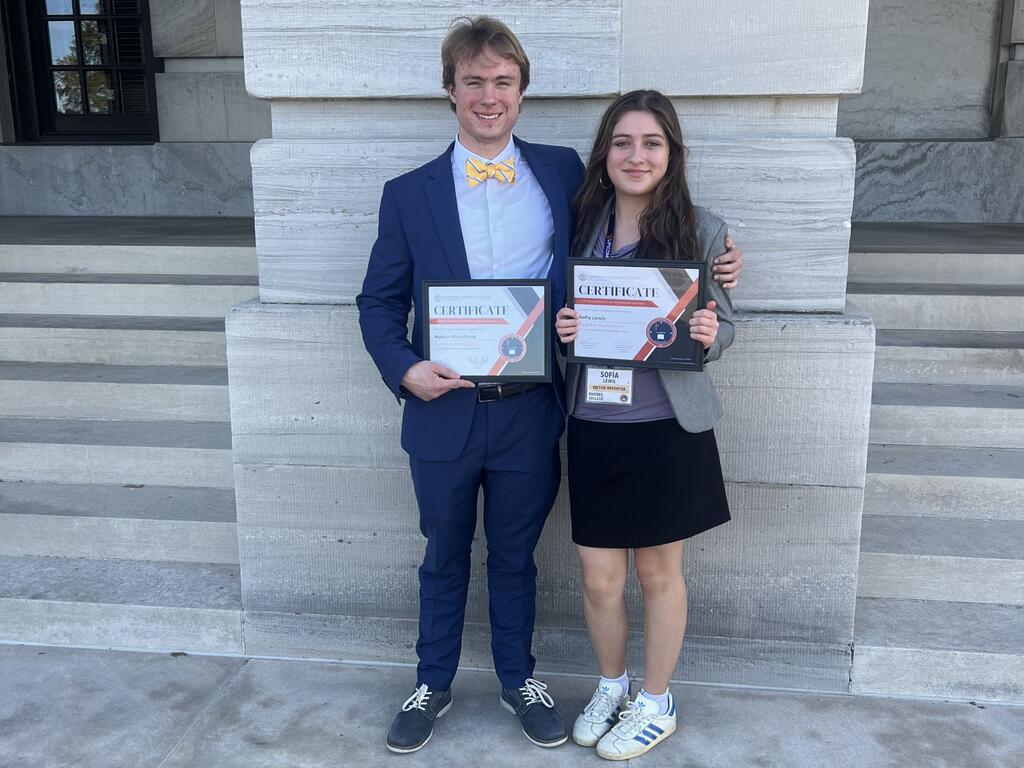 image of two Rhodes College students holding certificates