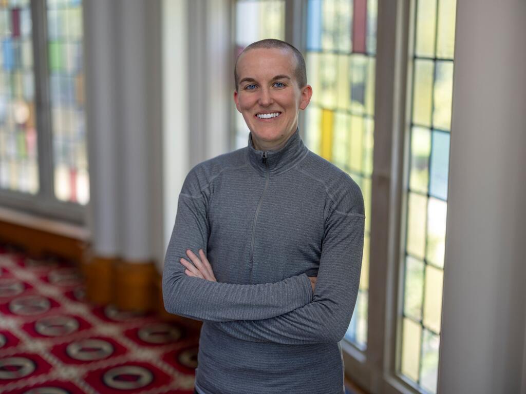 image of Beck Henriksen standing in front of a stained glass window