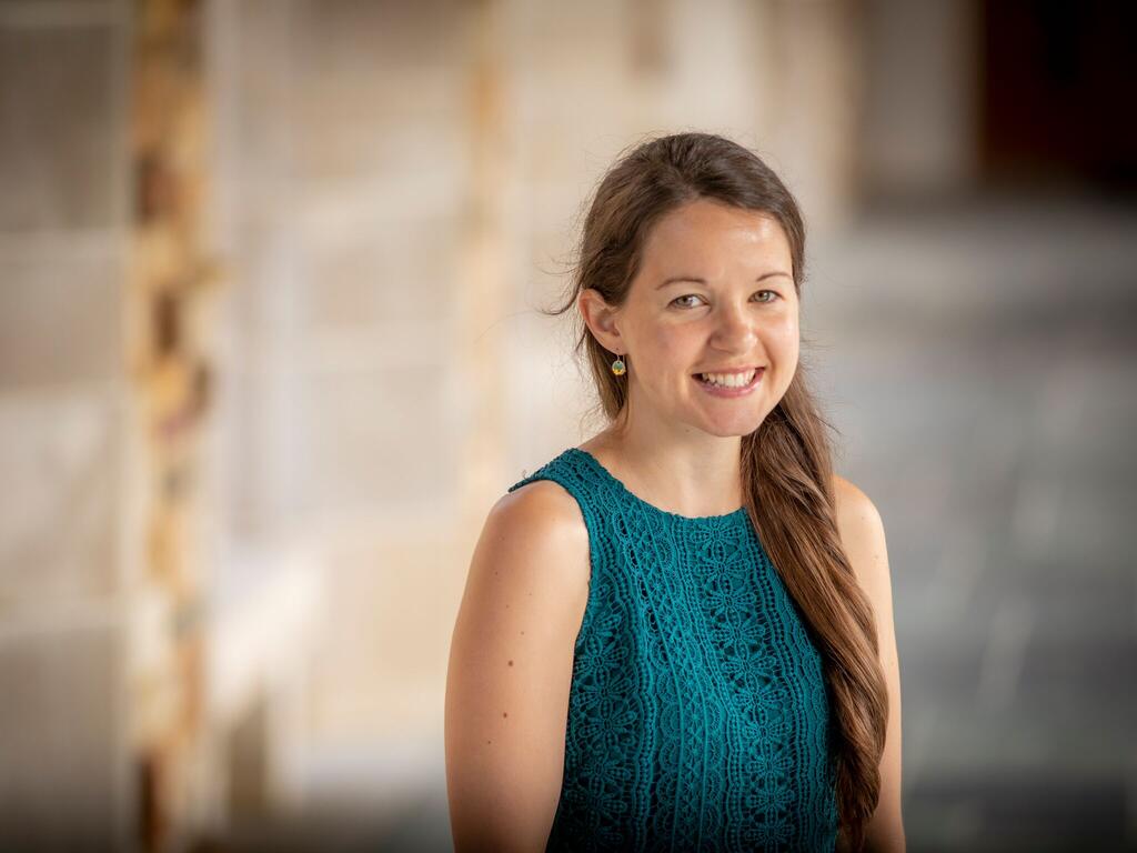 image of Laura Shanahan standing in front of a stone building on Rhodes College campus