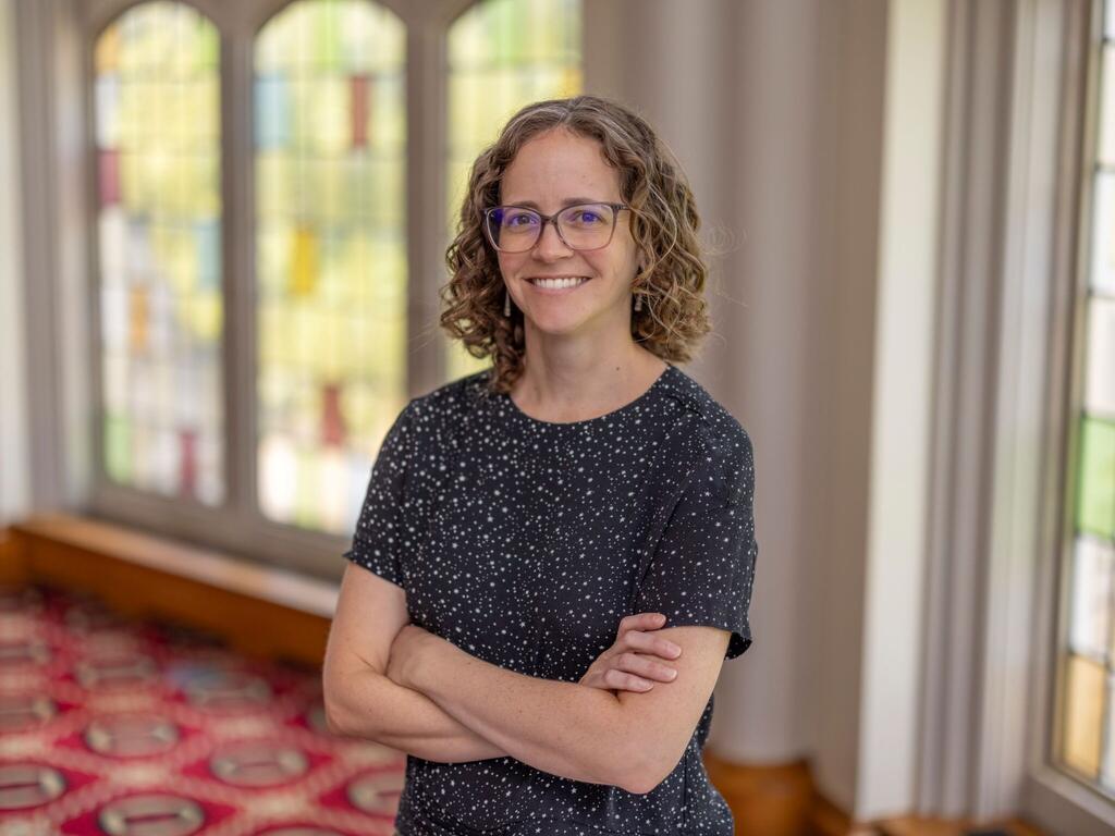 image of Laura Kelly standing in front of a stained glass window