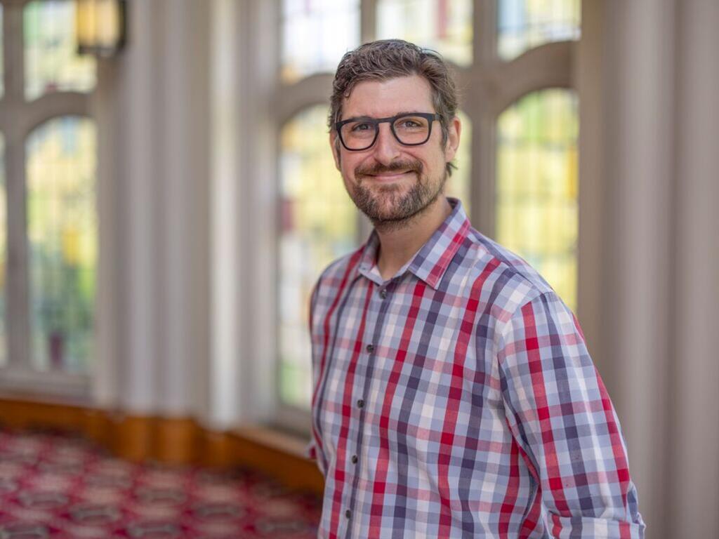 image of Zac Casey standing in front of a stained glass window