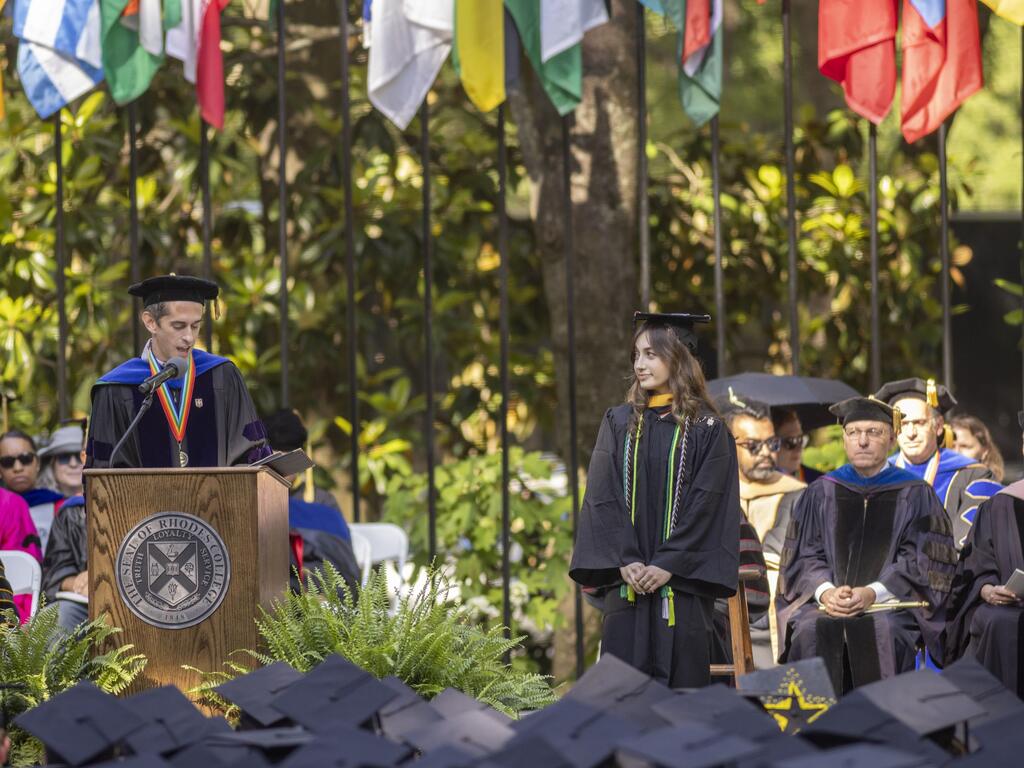 Hannah Meit standing  at the podium, while remarks are read about her achievements
