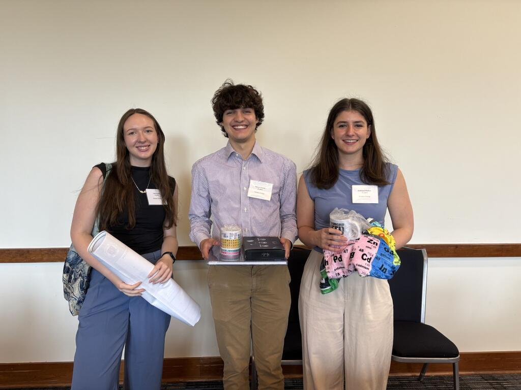 group photo of Rhodes students with their posters and awards