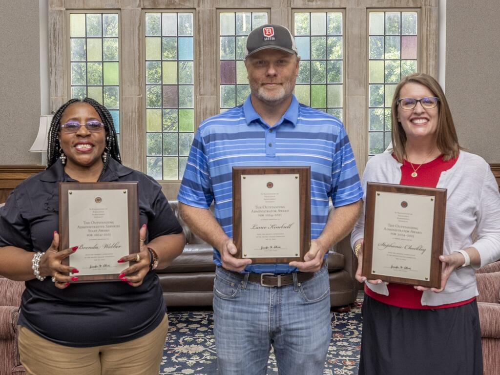 Rhodes College staff members holding plaques