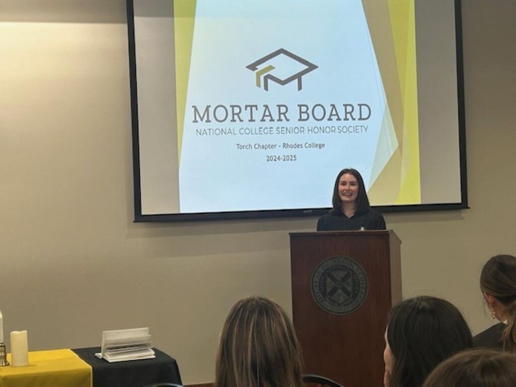 image of individual at the podium, in front of Mortar Board sign