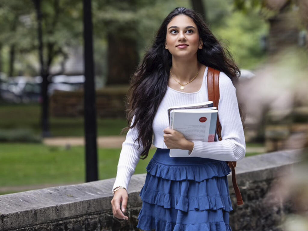 a young woman walks on campus