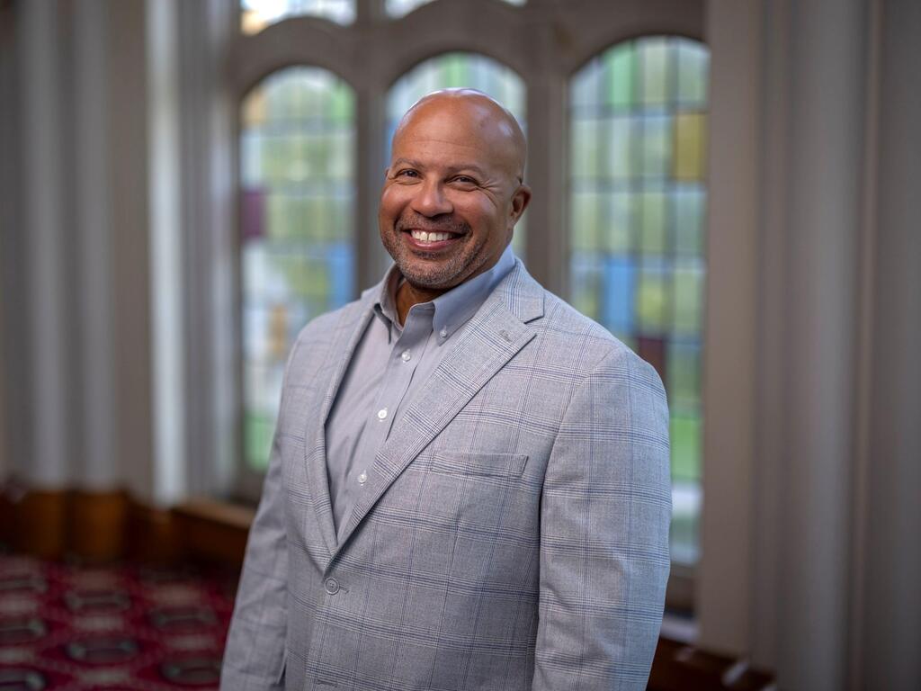 image of Michael Morgan standing in front a a stained glass window