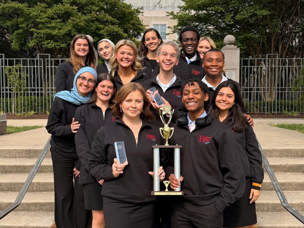 group photo of Rhodes mock team members holding trophy