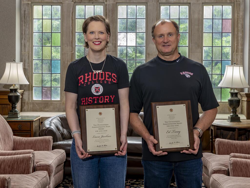 Laura Jacobsen and Ed Trouy, standing next to each other, holding individual plaques