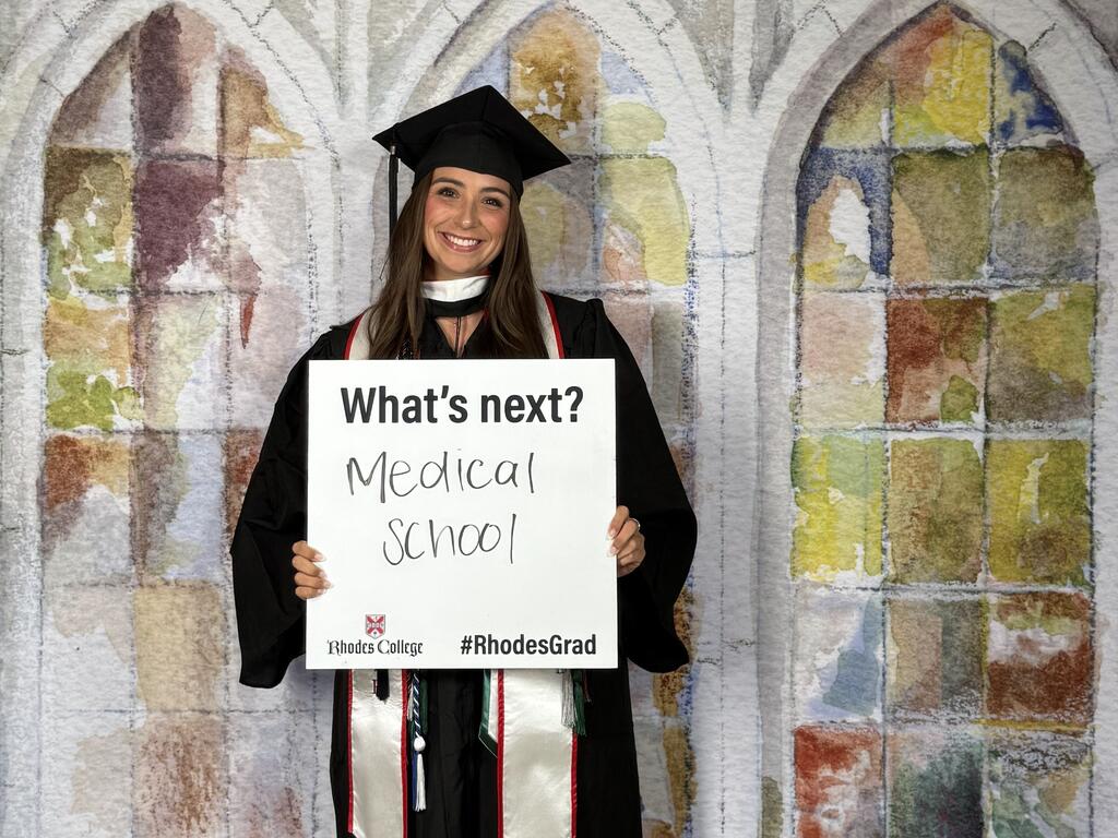 Rhodes College graduate holding sign about going to med school