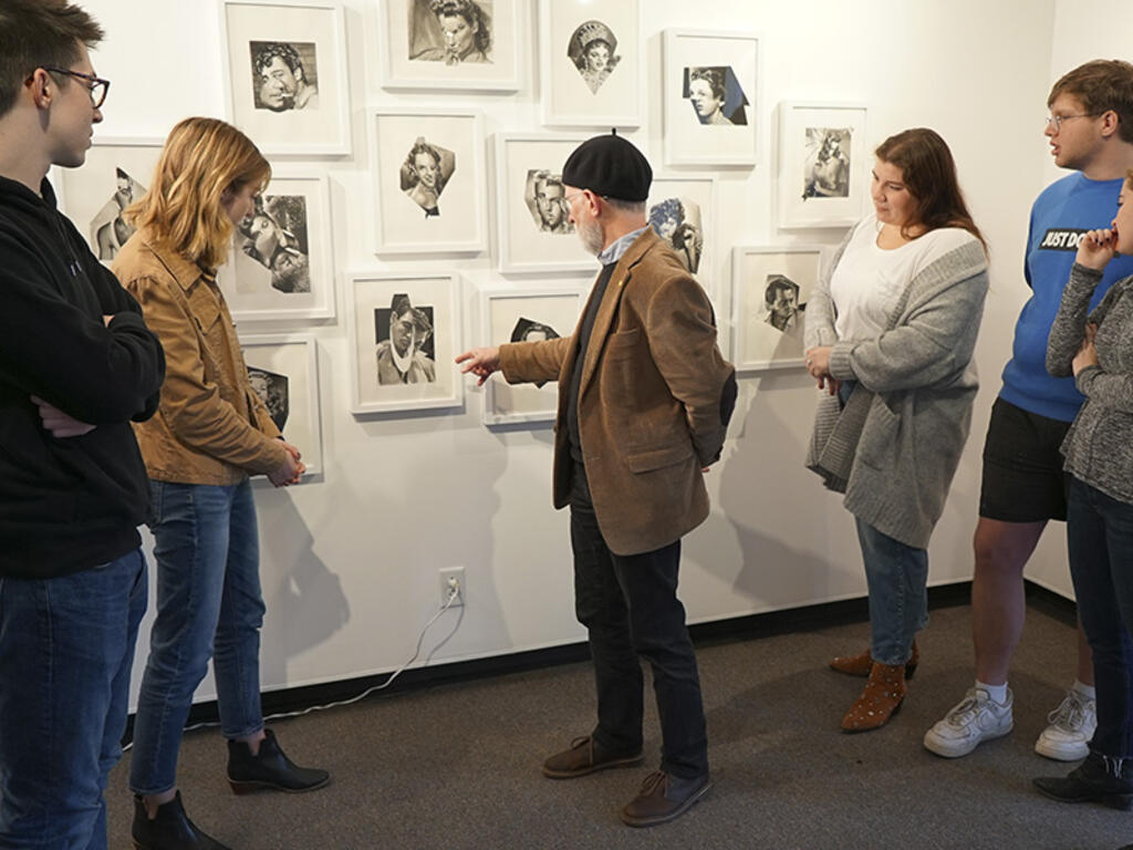 a professor discusses art in a gallery with students