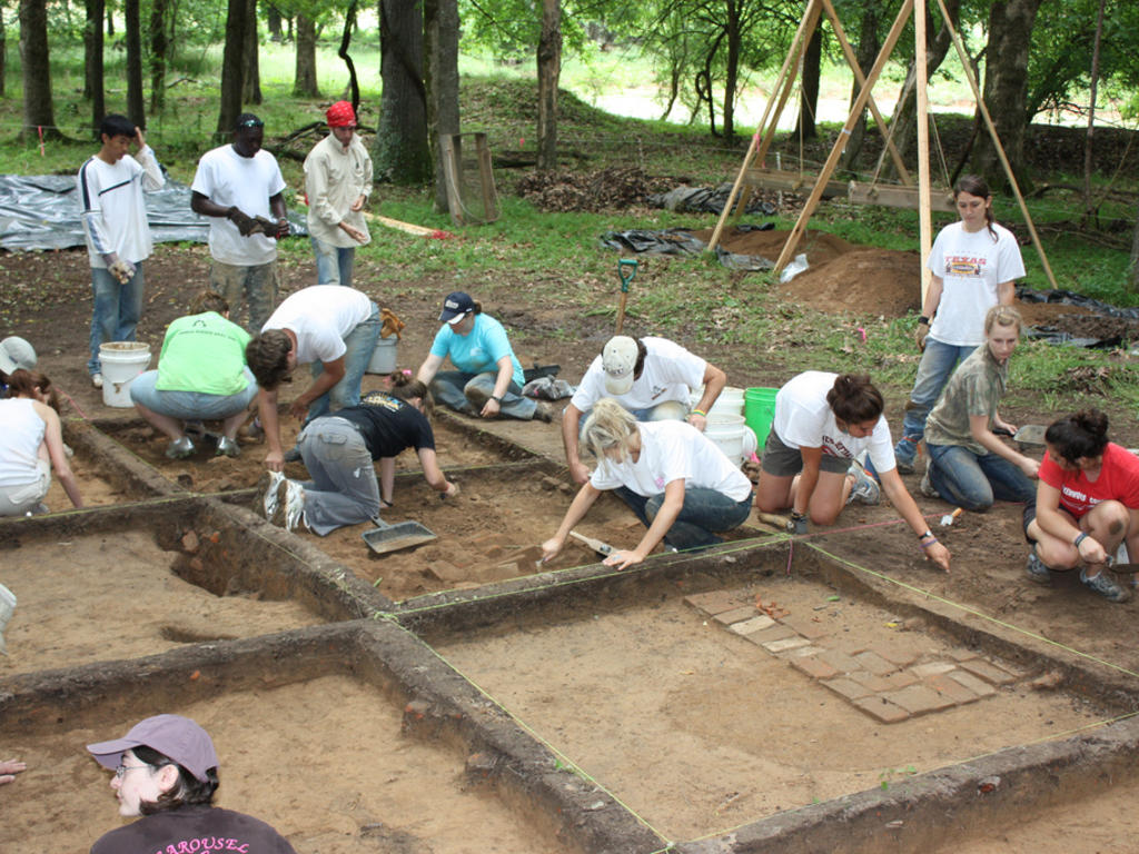 students work on an archaeological dig laid out in grids