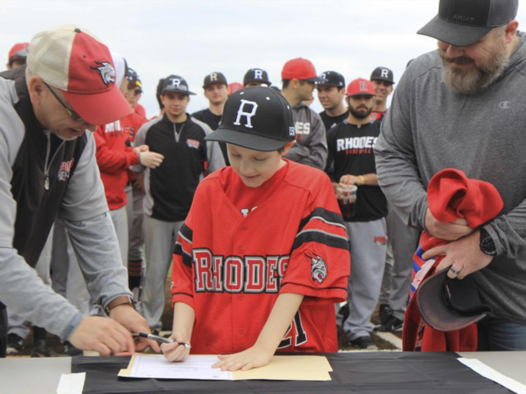 A young boy with baseball players