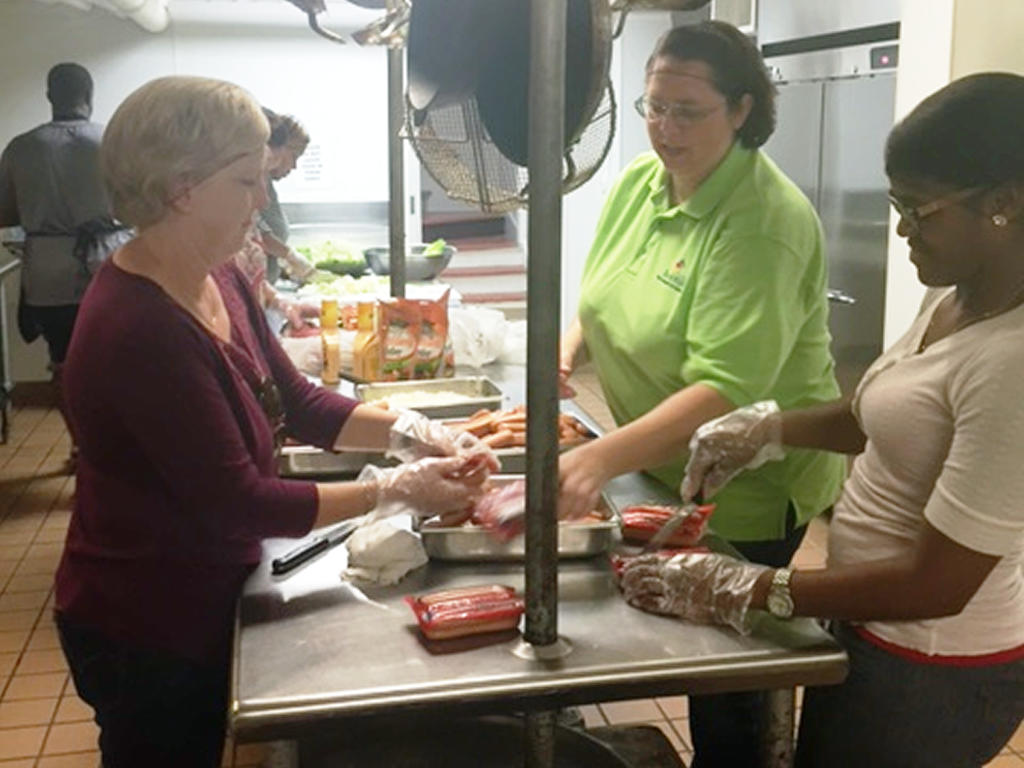a group of volunteers working at a soup kitchen