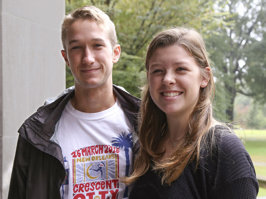 a young female and male student smirking at the camera