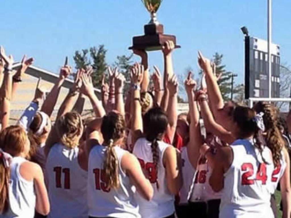 Photo of the Rhodes College Field Hockey team holding up a trophy.