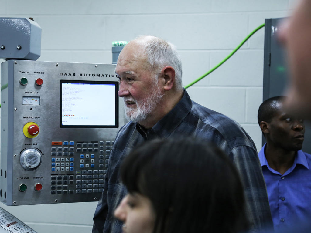 individuals standing in front of an automation machine