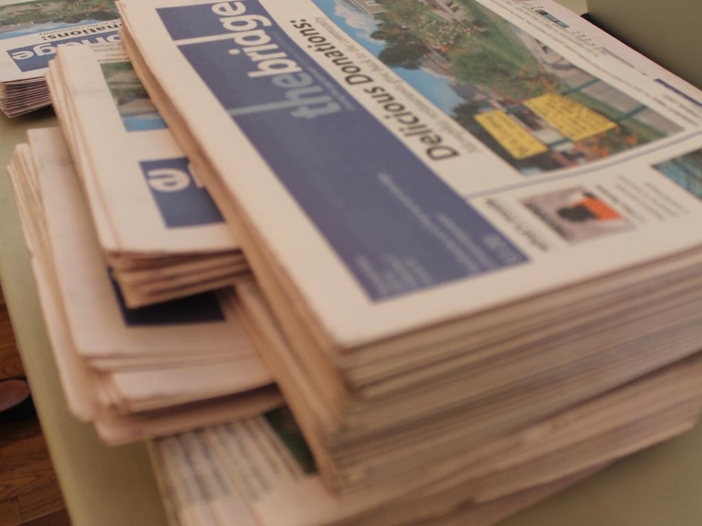Photo of a stack of newspapers printed by The Bridge Street Newspaper Organization.