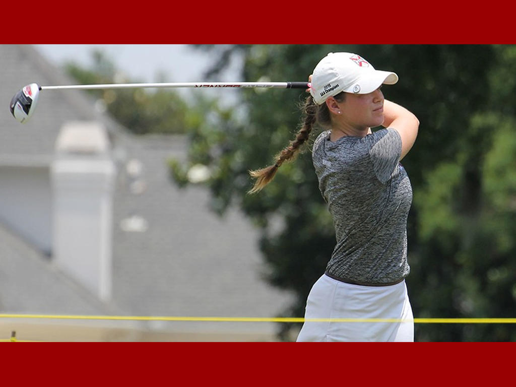 a female golfer concentrating in mid-swing