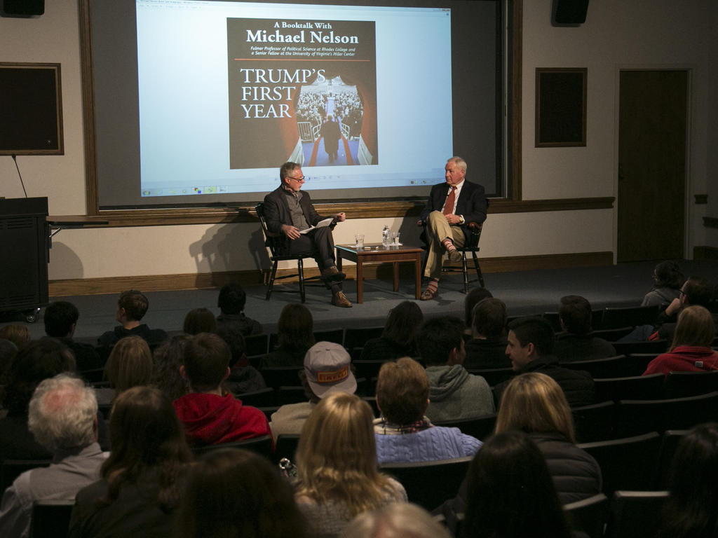 seated author discussing book on stage