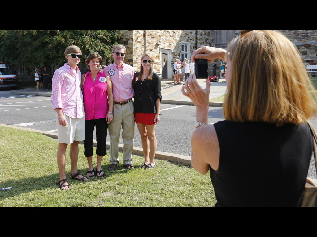 a woman taking a photo of a family 