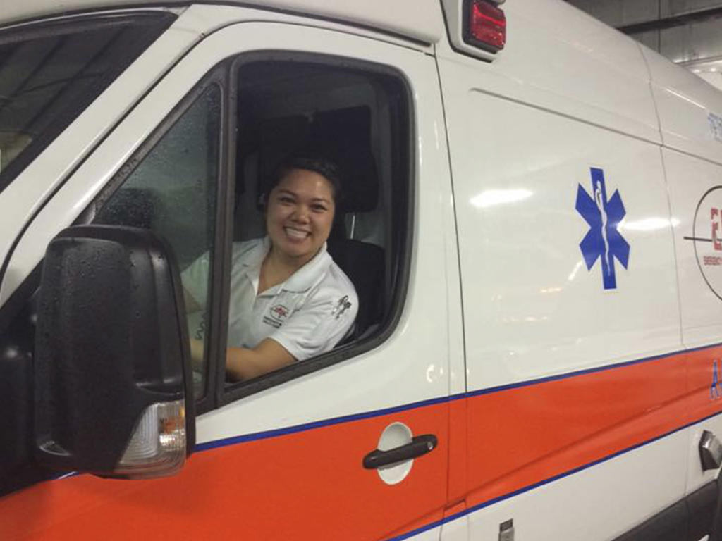 a woman sitting behind the wheel of an ambulance