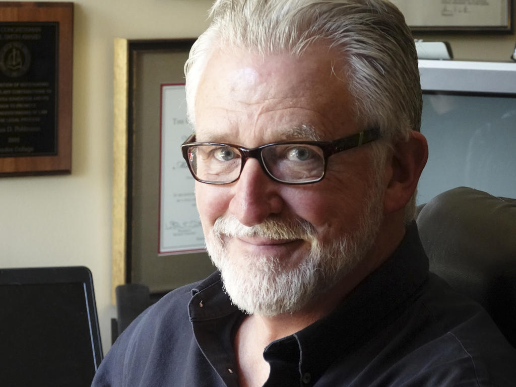 Portrait from shoulders up of bespectacled white-haired and bearded man