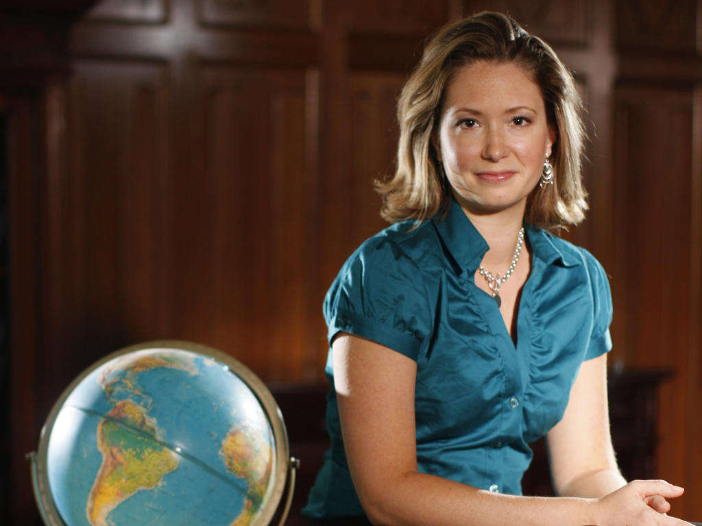 a female professor leaning on a desk