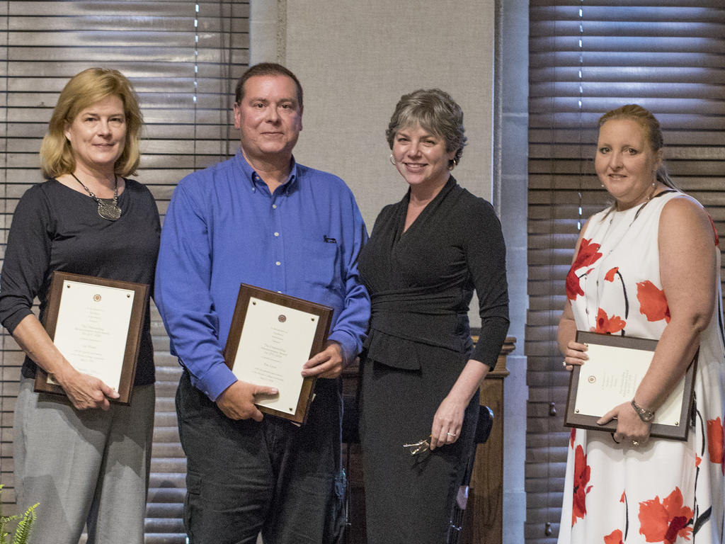 group photo of college staff holding award plaques