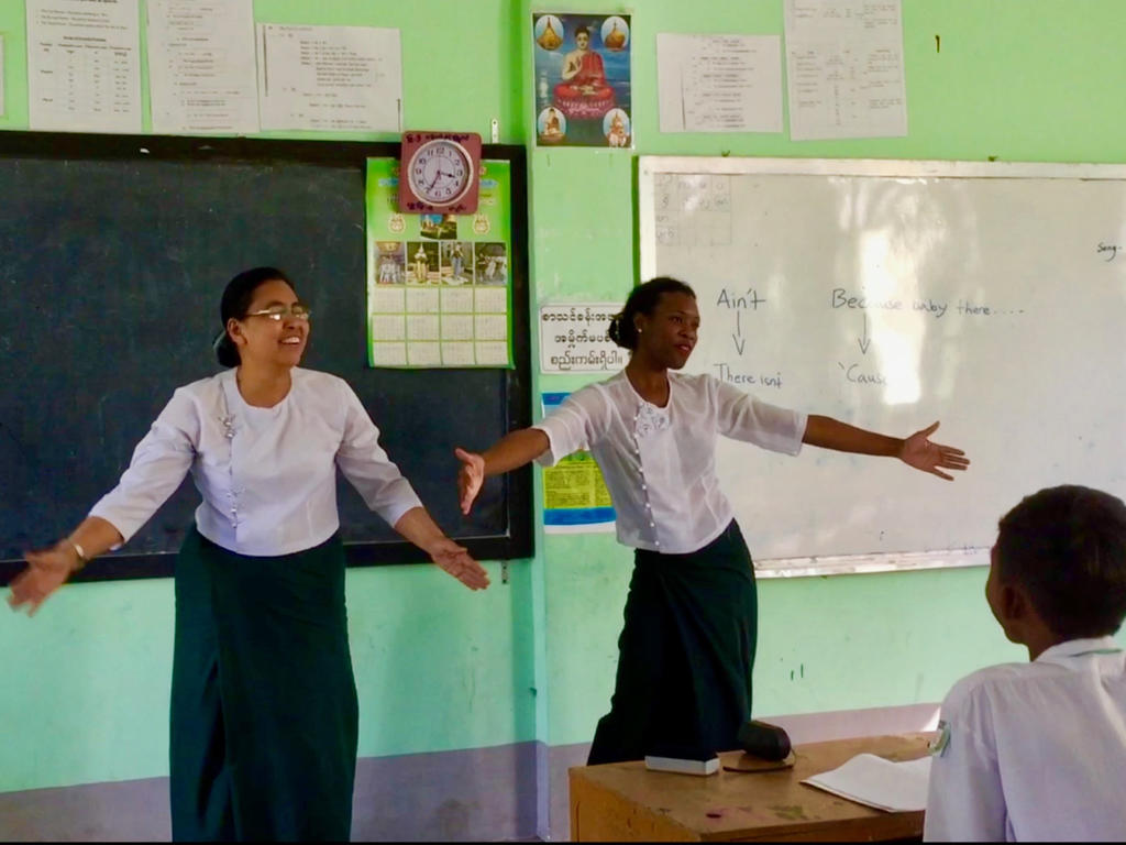 two teachers giving a demonstration in front of a classroom