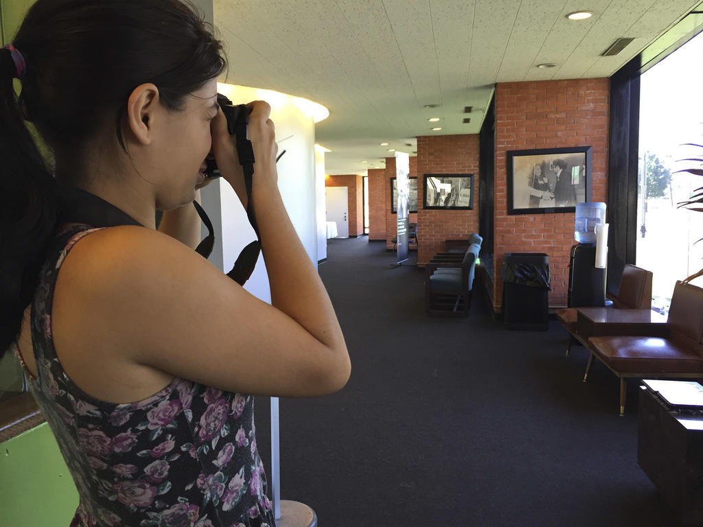 a student taking a picture of chairs lined up against windows