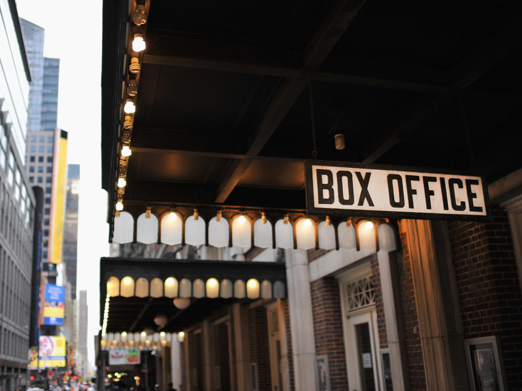 a box office sign attached to a building located in a downtown, metro area