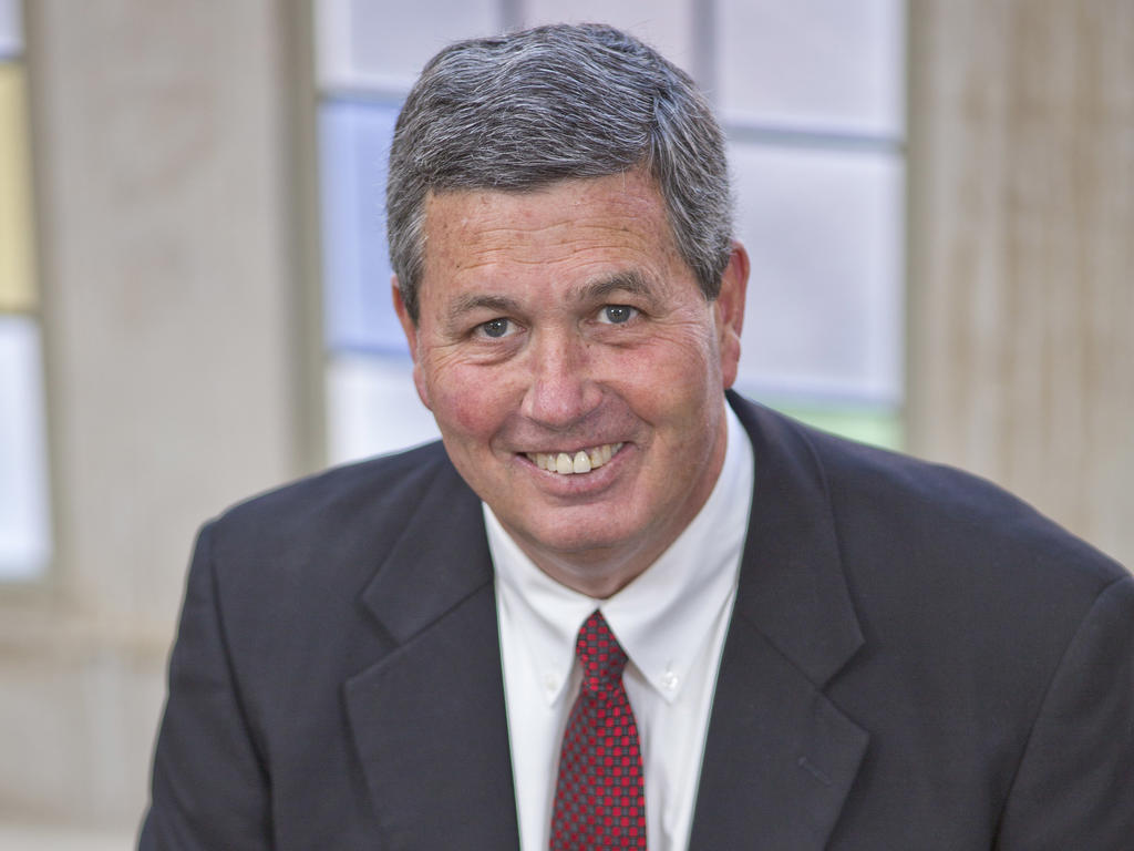 a middle aged white male smiling in professional attire