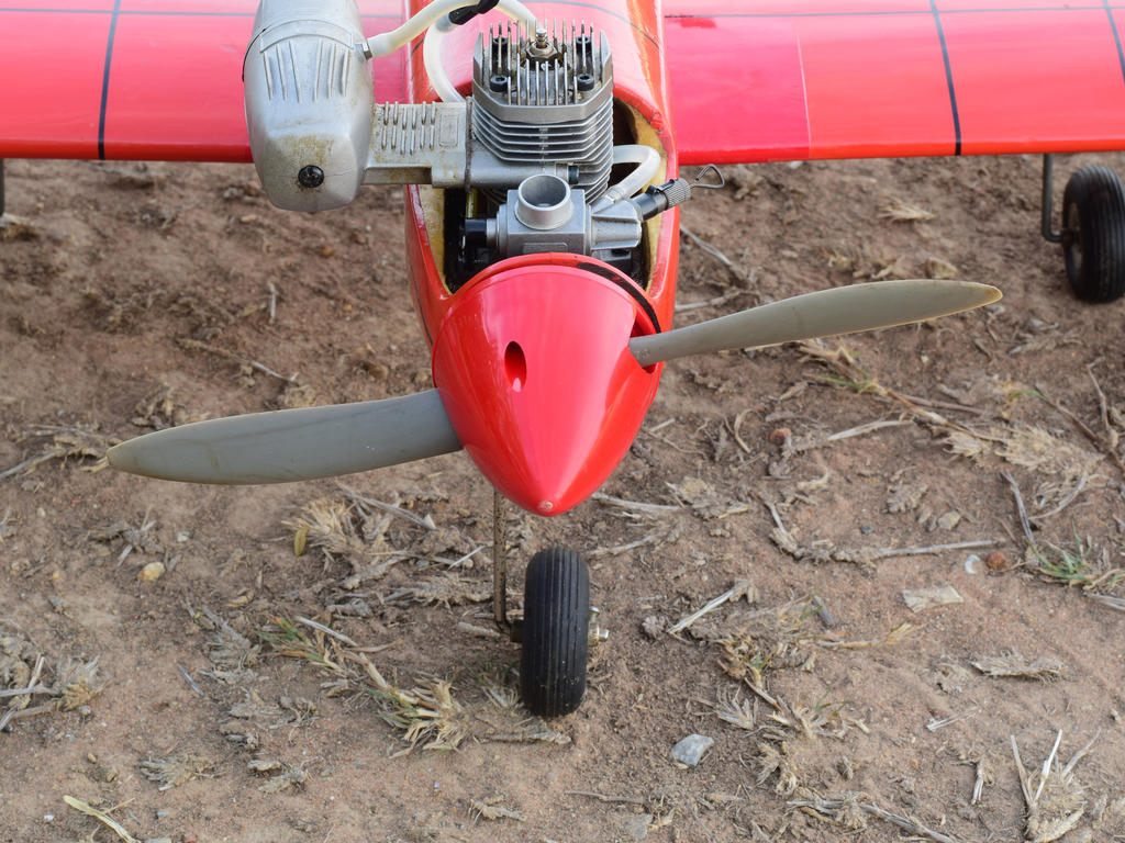 The nose and part of the wings of a small model of a red airplane