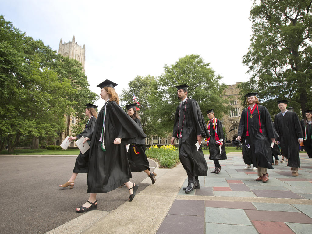 a diverse group of collegiates crossing the street in a clump